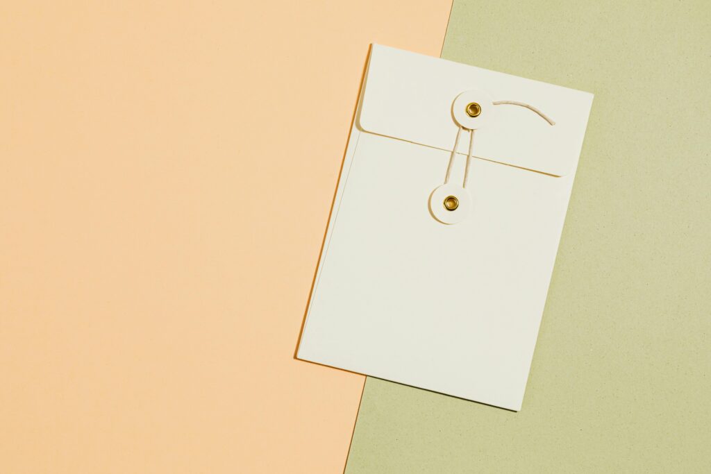 Flat lay of a string-tied envelope on a pastel backdrop ideal for presentations.